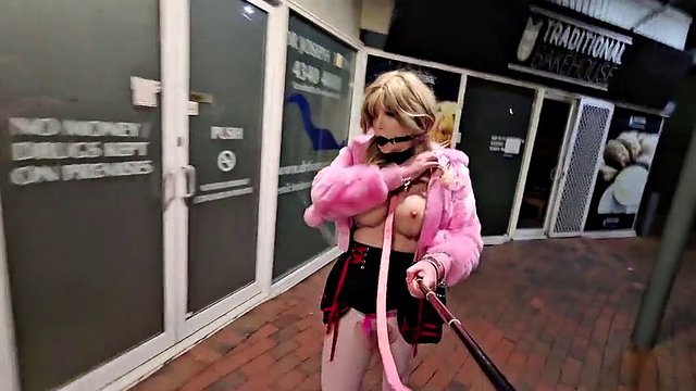 Sissy gagged and on a leash outdoors