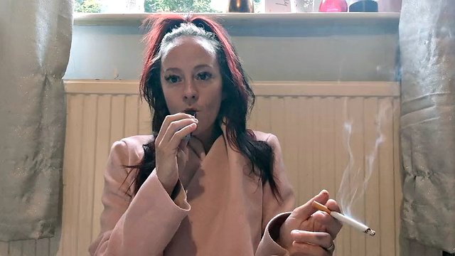 Bonita de rosa, Kitty fuma y vaporiza con su lápiz labial.