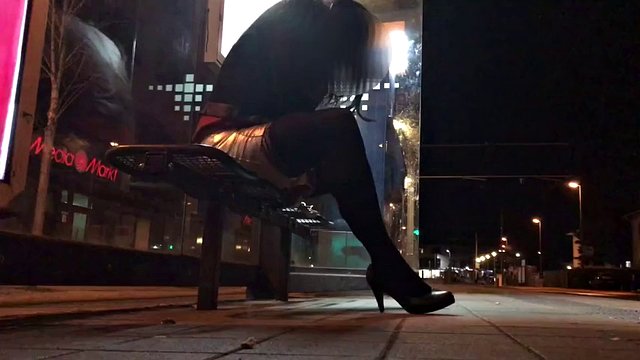 Crossdresser fixed on a bench in a tram station