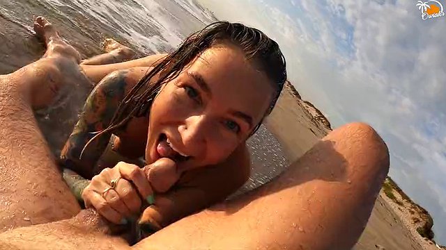 Pareja real divirtiéndose en la playa nudista. Mamada mojada sexy