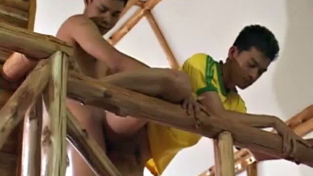 We look in on Asian boy Kob, busy licking and sucking Wut's cock and balls. Soon they are on the stairs where Kob continues to toy with Wut's stiff dick, until he fires his load  onto Kob's red shirt.
