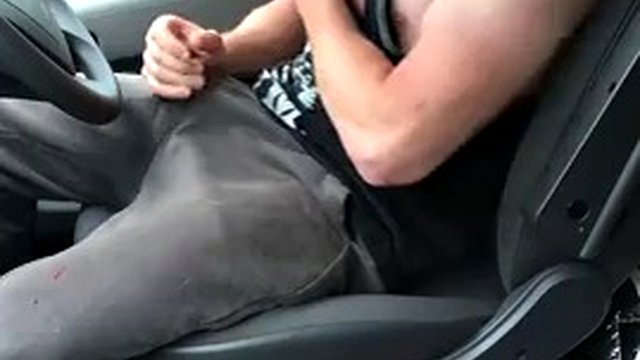 Muscular trucker in a sports vest with a huge dick bends over and jerks off in the cab of the truck