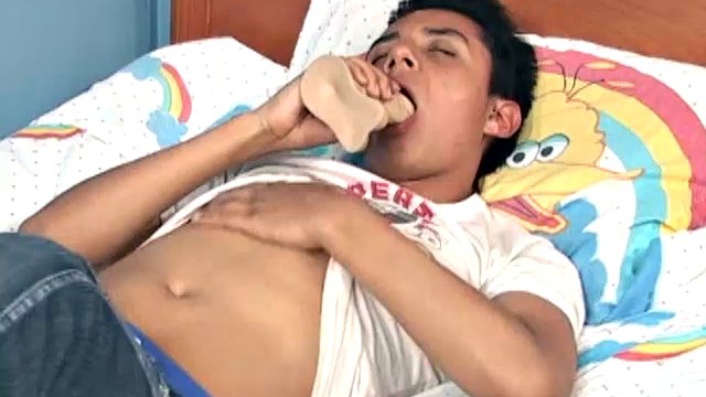 Latino boy John sucks on a dildo, while stripping naked and getting a boner. Once he's hard, that sex toy finds a home inside his ass.